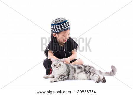 Close up of cute muslim boy playing with persian cat on white background isolated.
