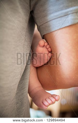 little feet. newborn baby in the arms of his father