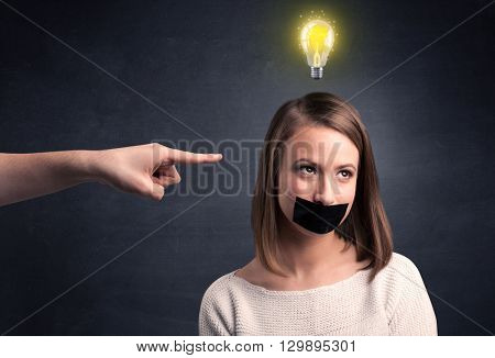 Caucasian hand pointing at female employee with a lightbulb above her head