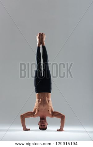 Man doing yoga headstand isolated on a white background