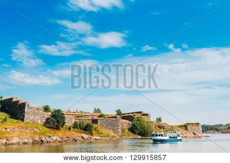 Tourist Boat Floats Near The Sea Fortress Of Suomenlinna. Historic Suomenlinna, Sveaborg Maritime Fortress In Helsinki, Finland. Sunny Day With Blue Sky