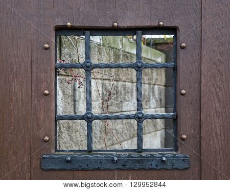 fragment of a wooden window with bars old door with small details