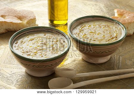Bowls with Moroccan bessara soup, olive oil and cumin  
