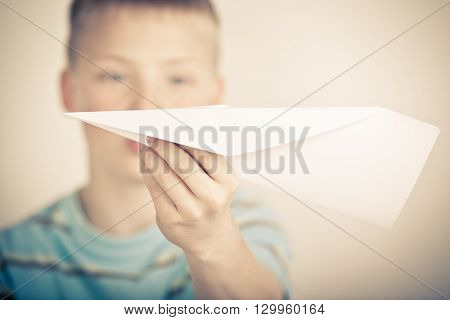 Out Of Focus Child Holding Paper Airplane