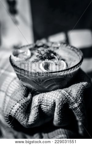 A Human Hand Holding Hot Bitter Gourd Smoothie With An Towel.