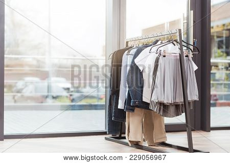 Various Clothes On Hager At Shop Interior Against Window