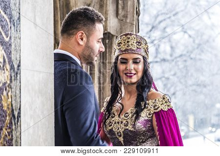 Happy Couple In Traditional Turkish Wedding Dress During Their Wedding In A Snow Storm