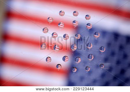 American Flag reflection in water drops. Refraction phenomena of American flag in water drops on glass. backgrounds and textures.    
