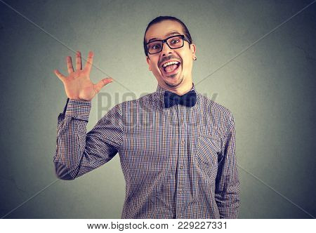 Portrait Of A Man In Eyeglasses And Formal Clothing Posing Crazily At Camera On Gray Background