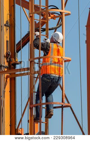 Rotterdam - Sep 8, 2012: Worker Climping Up A Straddle Carrier In A Shipping Terminal In The Port Of