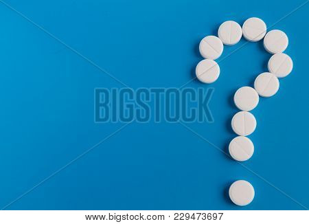 Question Mark From White Tablets On A Blue Background. The Medical Concept.