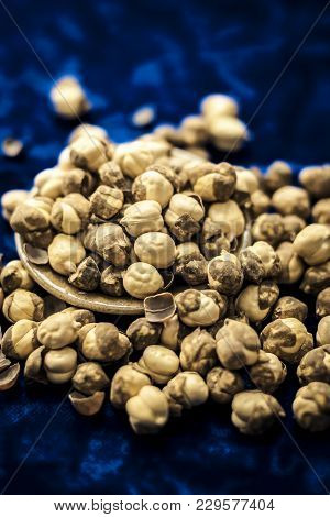 Close Up Of Baked Or Roasted Chickpea/channa Or Dalia In A Bowl On A Blue Surface.
