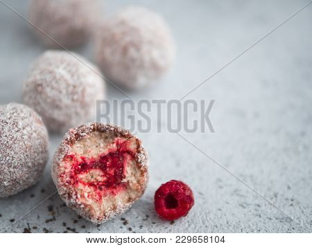 Raw Vegan Lamington Bliss Balls With Raspberries Chia Jam On Gray Background. No Baked Healthy Vegan