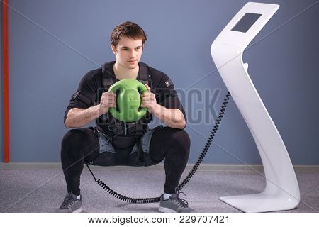Fit Man In Ems Suit Training With Medecine Ball