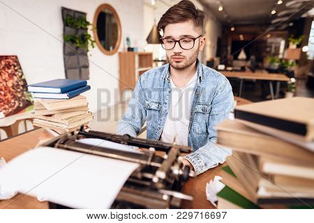 Freelancer Man In Jeans Shirt Typing At Old Typewritter Sitting At Desk.