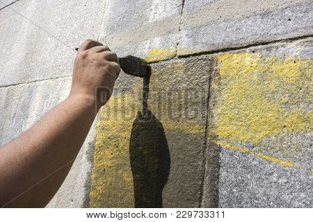 Man With The Help Of A Wet Brush Erases The Graffiti Painted On The Wall. Preparation Of The Surface