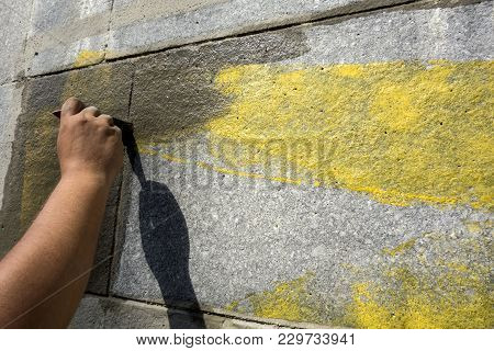 Man With The Help Of A Wet Brush Erases The Graffiti Painted On The Wall. Preparation Of The Surface