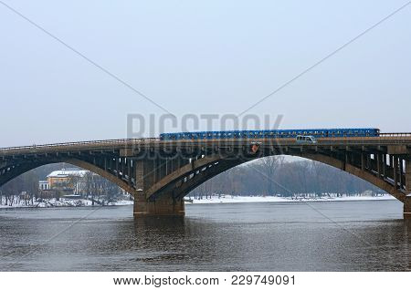 Metro (subway) Bridge With One Train. The Metro Train Rides The Bridge. Light Snow, Winter Morning. 