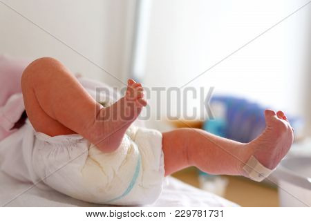 Feet Of Newborn Child Seconds And Minutes After Birth. Cute Tiny New Born Baby Girl On Towel. New Li