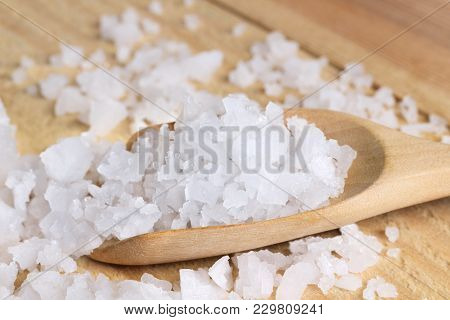 Sea Salt In A Wooden Spoon On The Table. Sea Salt Is Used For Seasoning, Preserving Food And Making 