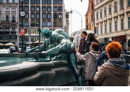 Vienna, Austria - 1 October, 2017: Woman Tourist Caresses Back Of Statue Of Ancient God For Luck. Do