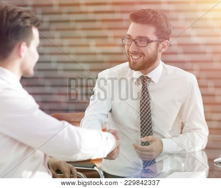 handshake colleagues sitting at your Desk