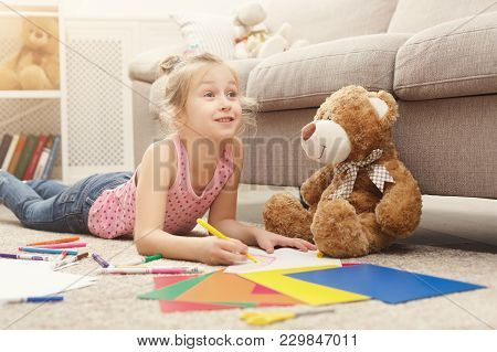 Happy Little Girl Drawing. Cute Kid Lying At Home On The Floor Among Cologed Paper And Pencils. Diy,