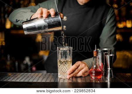 Barman Serving An Adorable Fresh Alcoholic Red Cocktail With An Cooled Ice On The Steel Gray Barstan
