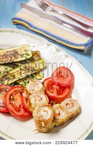 Spiedini Of Pork Meat And Cheese On Skewer, Grilled Green Zucchini An Tomatoes Cutting In Circles.