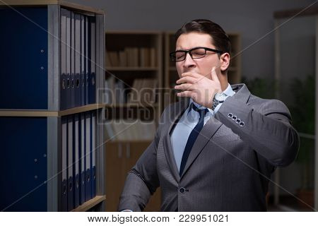 Businessman almost falling asleep working late hours in the offi