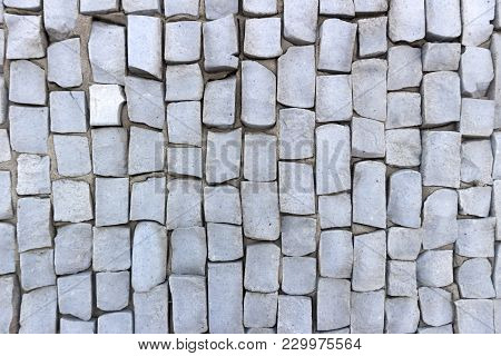 Light Blue Smalt Pebbles On Gray Cement Wall.