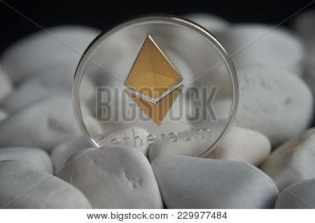 Silver Ethereum Coin Stuck Between White Stones. Cryptocurrency Mining Concept, Selective Focus.