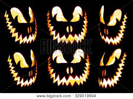 Collection of scary Halloween pumpkin Jack o lantern faces glowing red and yellow eerily on black