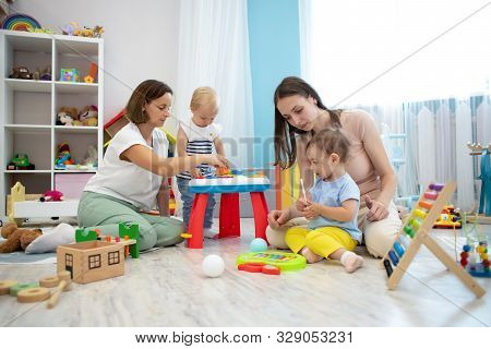 Kids Playing On Floor With Educational Toys. Toys For Preschool And Kindergarten. Children In Nurser