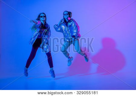 Young Stylish Girls Dancing In The Studio On A Colored Neon Background. Music Dj Poster Design.