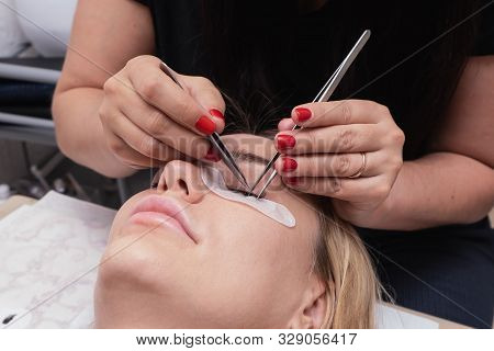 Beauty Saloon. Close-up, Procedure For Eyelash Extension. The Master Glues Each Cilium With Special 