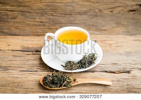 Dry Gynostemma Pentaphyllum Leaf With Brewed Tea In A White Cup On The Wood Floor