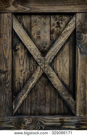 Detail Of Old Wooden Door With Weathered Planks, Cross, Knots And Rings.