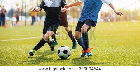 Two Soccer Players Running And Kicking A Soccer Ball. Legs Of Two Young Football Players On A Match.