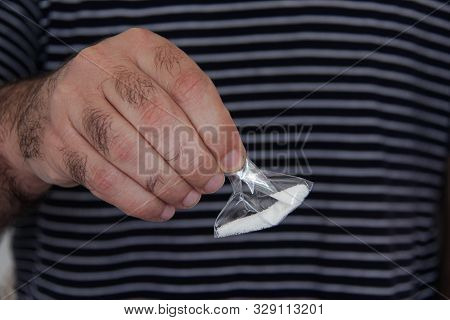 Man Picking Up A Packet Of Sugar .sugar Is A Drug.like Cannabis.