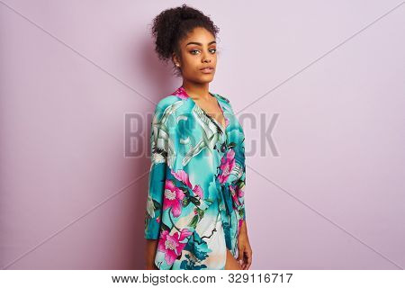 Young beautiful african american woman standing wearing elegant colorful caftan