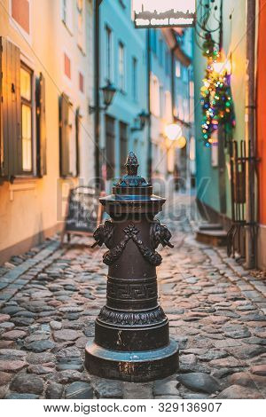 Riga, Latvia. Small Column Pillar Shaft Stake Pile With Lions Heads At Torna Street In Old Town. Nar