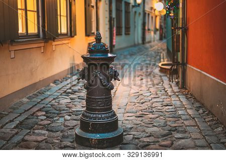 Riga, Latvia. Small Column Pillar Shaft Stake Pile With Lions Heads At Torna Street In Old Town. Nar