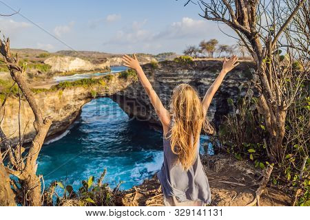 Young Woman Tourist Near Broken Beach In Nusa Penida, Indonesia Angels Billabong Beach. Popular Tour