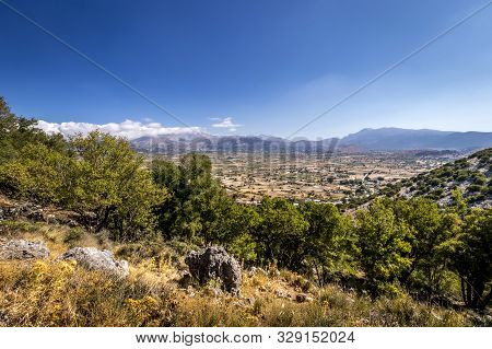 Top View Of The Lassithi Plateau On A Sunny Day With Cloudy Sky.