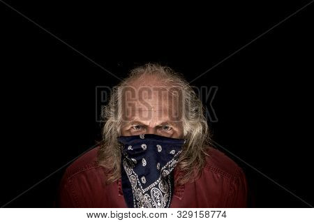 Portrait Of Llong Haired Masked Bandit Wearing A Blue Bandana To Cover The Face And A Red Shirt Look