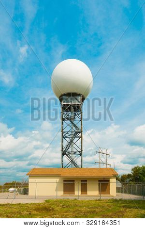 Weather Radar Tower Against Blue Sky With Clouds.