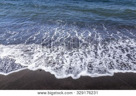Sea Surf On The Beach With Black Volkanic Sand.