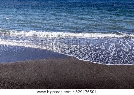 Sea Surf On The Beach With Black Volkanic Sand.