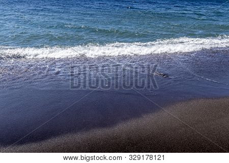 Sea Surf On The Beach With Black Volkanic Sand.
